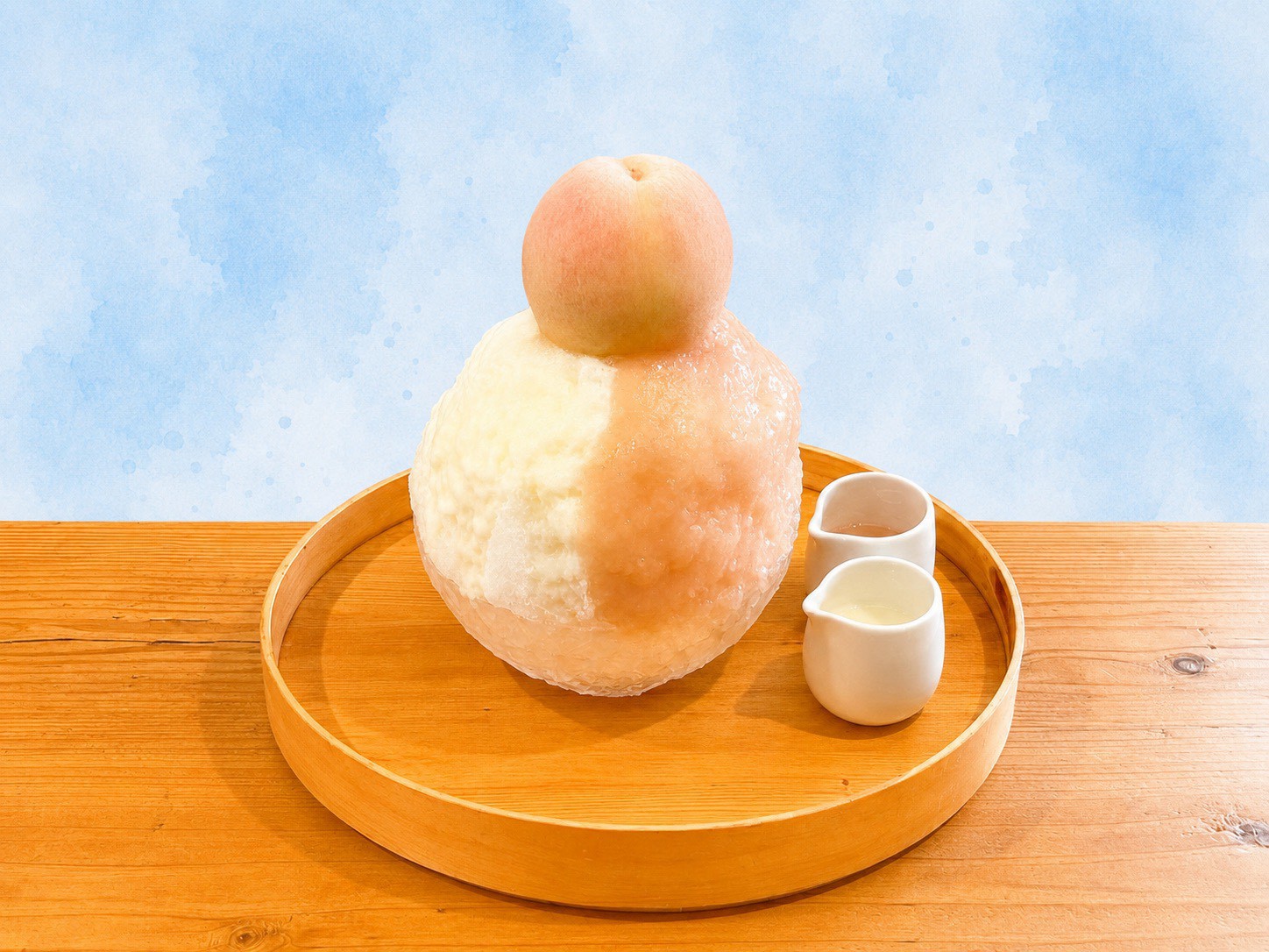 丸ごとの桃をのせた、しろいくものかき氷